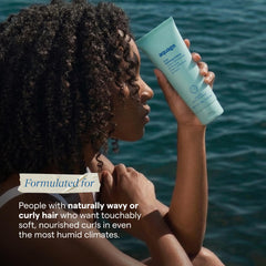 Curly-haired model using Aquage cream for defined frizz-free curls and natural shine