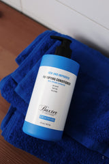 Baxter of California creamy conditioner texture on palm showing lightweight hydration and detangling