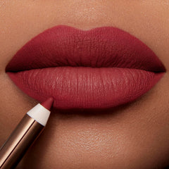 Charlotte Tilbury swatches on varied skin tones demonstrating flattering rosy-red payoff