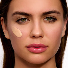 Clarins model applying tinted SPF 50 for natural coverage and pollution defense