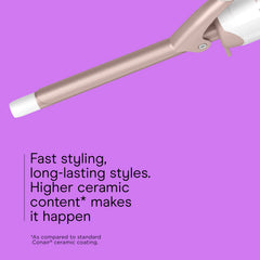 Conair curling iron held in hand to show scale and ergonomic design for comfortable styling