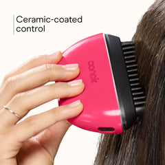 Conair brush beside hand showing scale and portable size for easy carrying