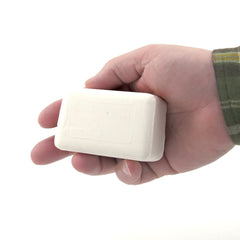Dermaharmony soap held in hand illustrating 4 oz size and portability
