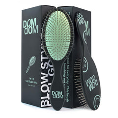 Dom Dom detangling brush front view showing green finish and ergonomic shape for comfortable grip