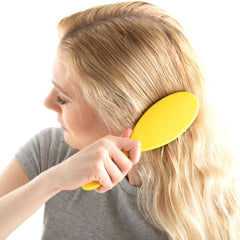 Drybar Super Lemon Drop in hand to show size and ergonomic grip for controlled styling