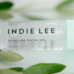 Indie Lee 30ml bottle next to coin for size comparison and travel convenience