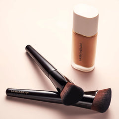Laura Mercier brush applying foundation to cheek for natural, even coverage
