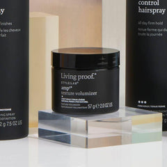 Model applying Living Proof Amp Texture Volumizer to dry hair, demonstrating root lift and natural textured finish