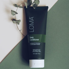 loma deep conditioner held in hand for scale emphasizing portable 8.45 ounce treatment
