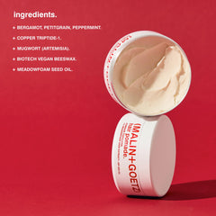 MALIN+GOETZ pomade on hands being warmed for even distribution and effective styling