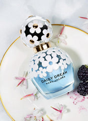 Marc Jacobs Daisy Dream close-up of cap and shoulder daisies, ornamental detail adds charm