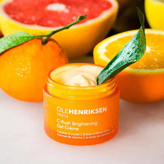 Ole Henriksen 1.7 oz tube beside citrus fruits to indicate vitamin C brightening