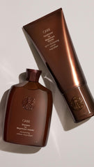 Oribe 6.8oz bottle beside common items to show size and pour amount for travel planning