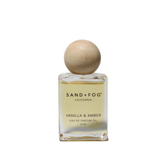 Sand + Fog front bottle showing clear glass and amber oil, elegant travel-ready design