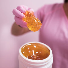 Melted Sugaring NYC paste on spoon demonstrating spreadable consistency for application