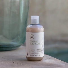 Tea Tree bottle in hand for scale, helps visualize the 10.14 fl oz size