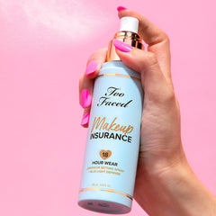 Too Faced 4 fl oz bottle beside hand for accurate size comparison