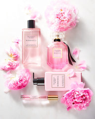 Victoria's Secret Bombshell lotion styled with perfume illustrating ideal layering for longer fragrance wear