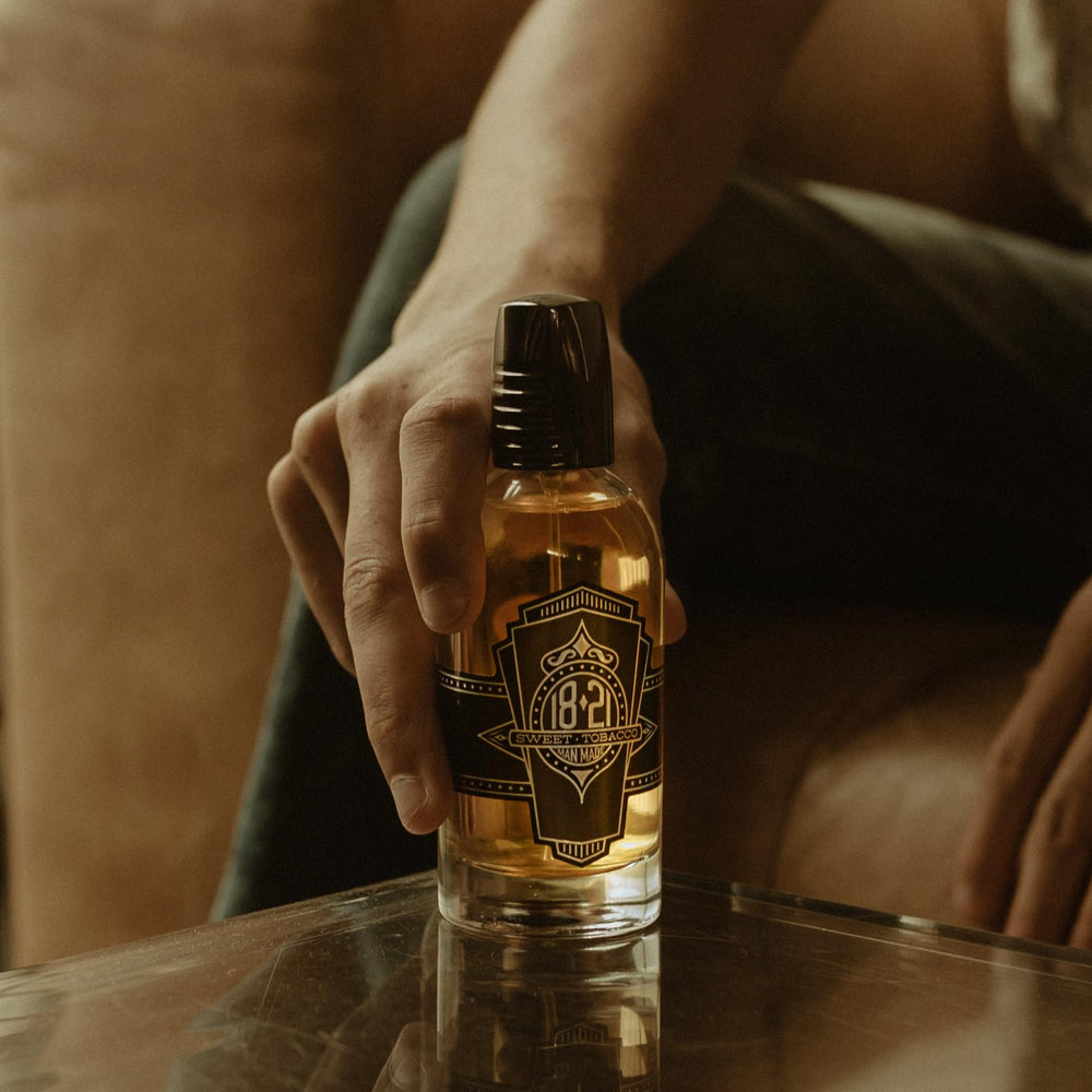 18.21 Man Made bottle in hand to show 3.4 oz scale and travel convenience
