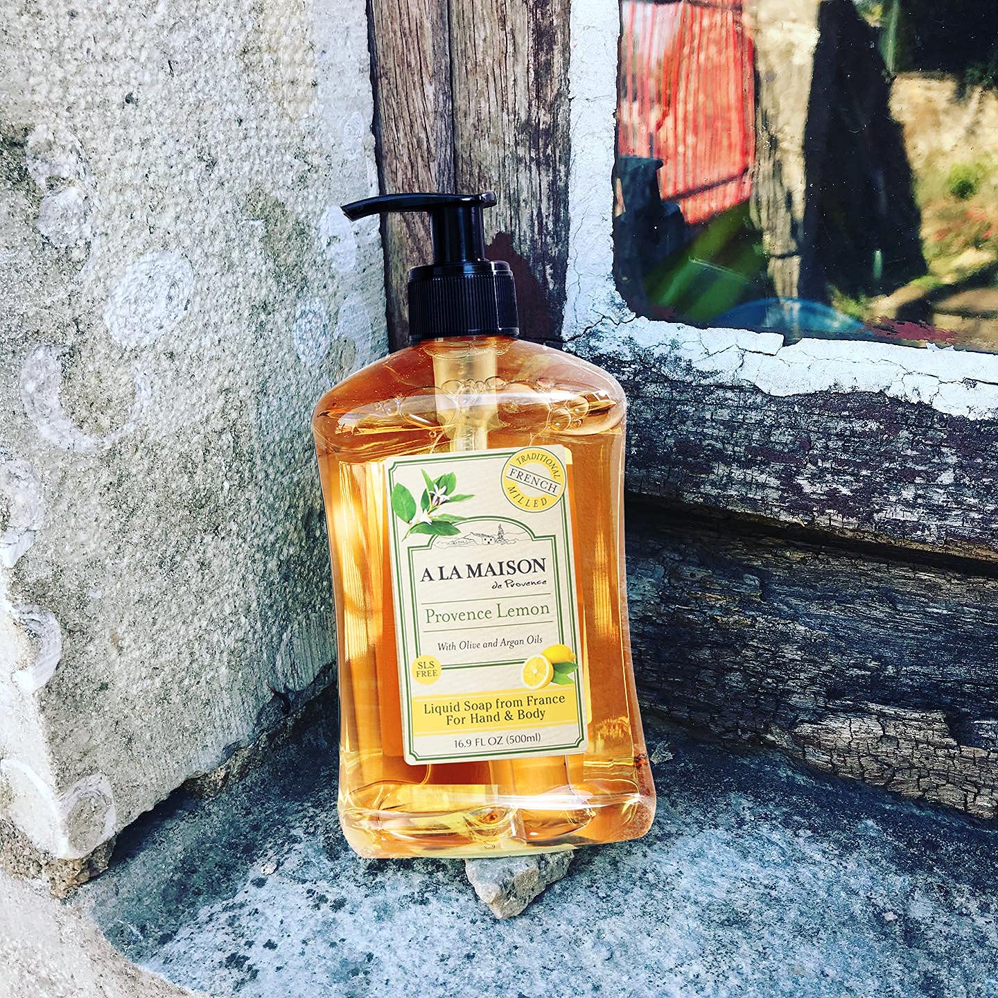 A LA MAISON bottle next to hand for scale showing 16.9 oz recyclable packaging