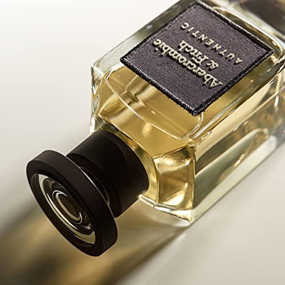 Abercrombie & Fitch bottle next to everyday objects showing 3.4 fl oz scale and travel convenience