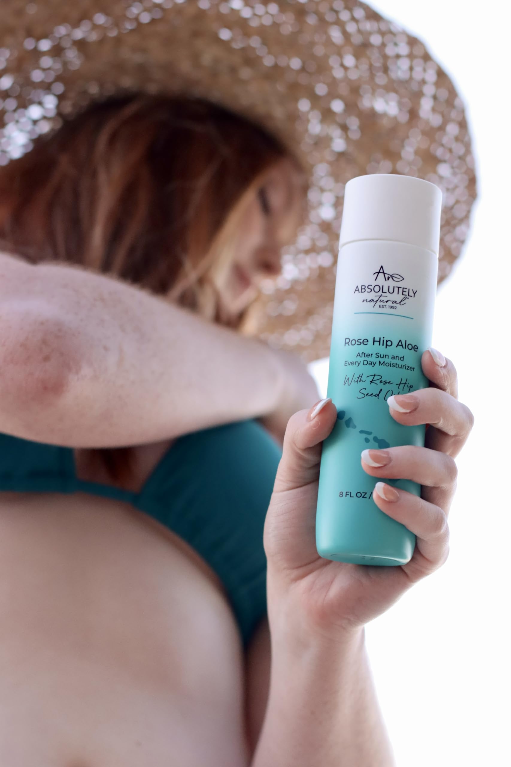 Absolutely Natural beside a hand for scale to show 8 fl oz convenience