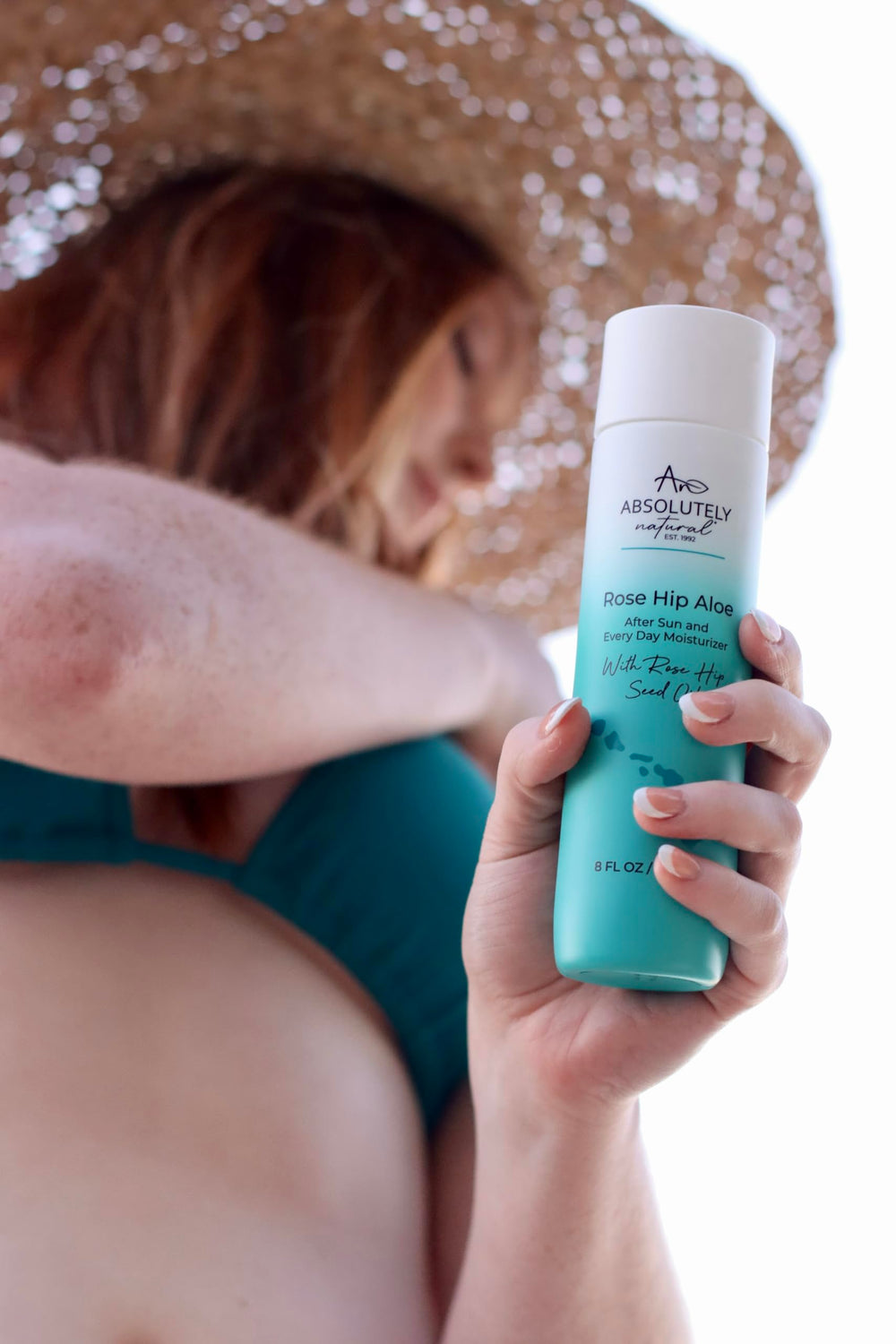 Absolutely Natural beside a hand for scale to show 8 fl oz convenience