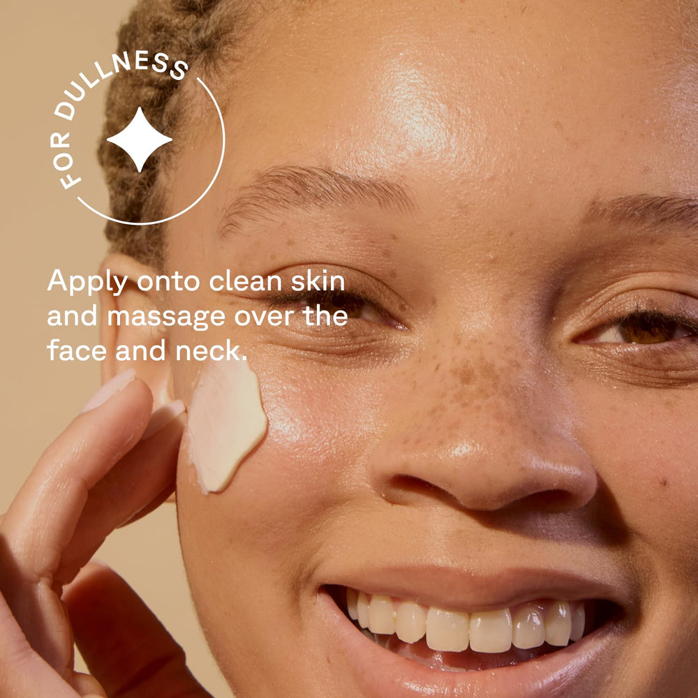 Acure brightening night cream next to hand showing 1.7 fl oz scale for size reference