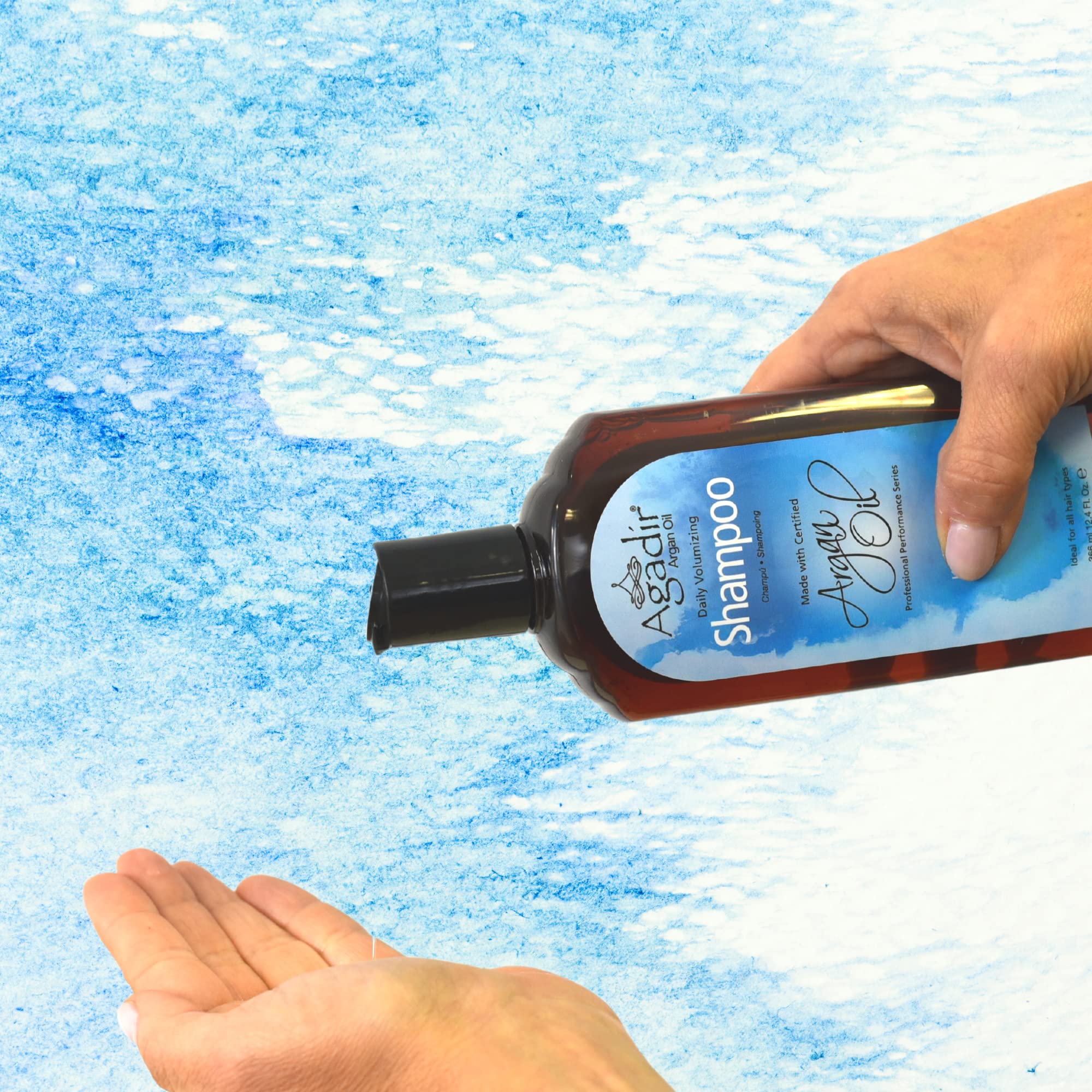 Agadir hand holding 12.4 fl oz bottle showing size and portability