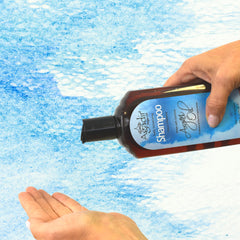 Agadir hand holding 12.4 fl oz bottle showing size and portability