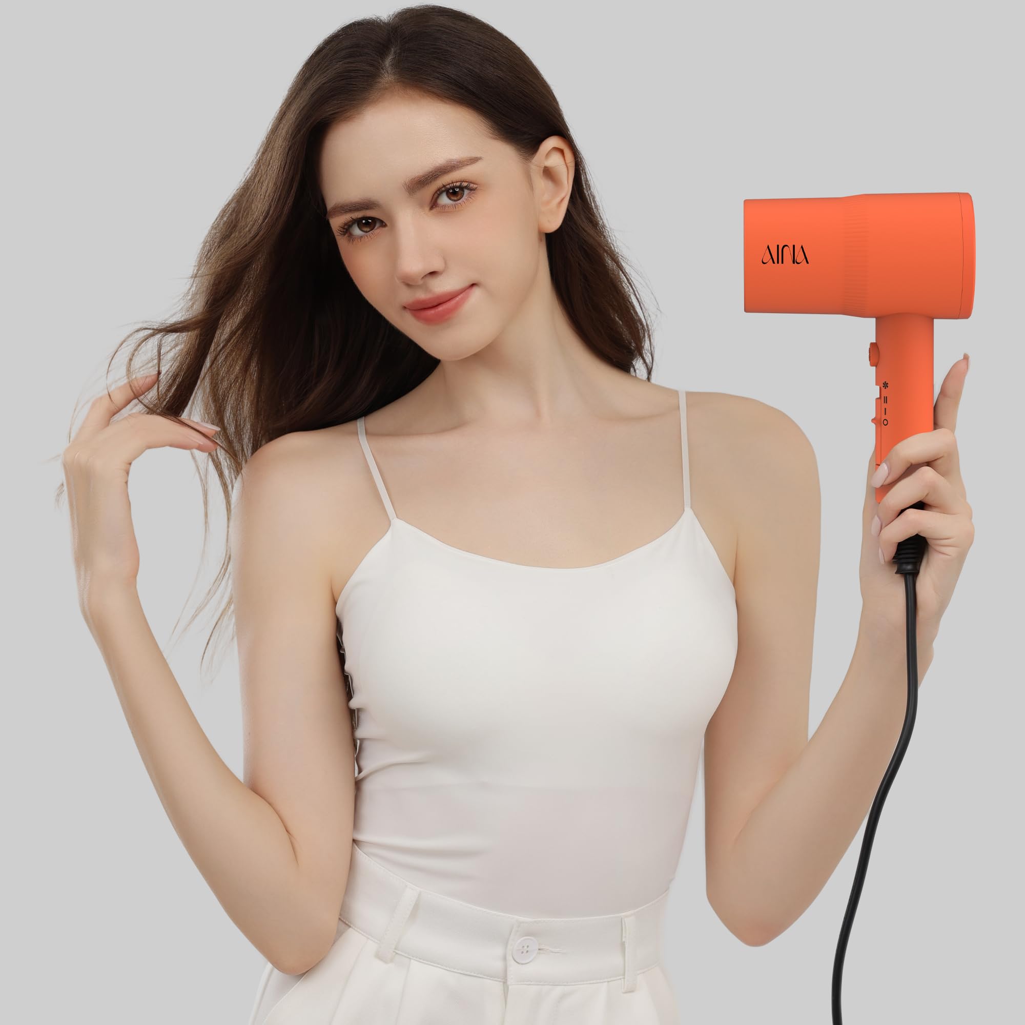 AINA dryer held in hand to show size and ergonomic handling benefit
