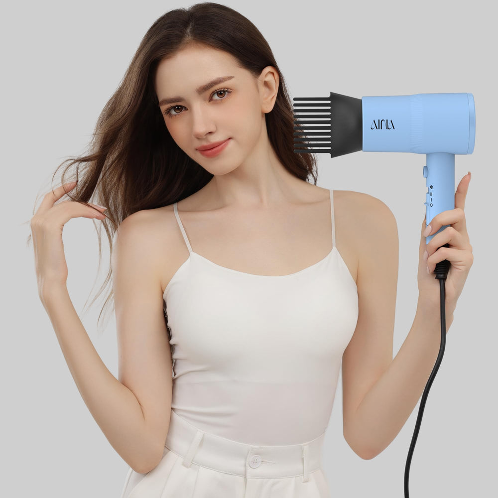 AINA hair dryer in use on curly hair delivering reduced frizz and defined shape