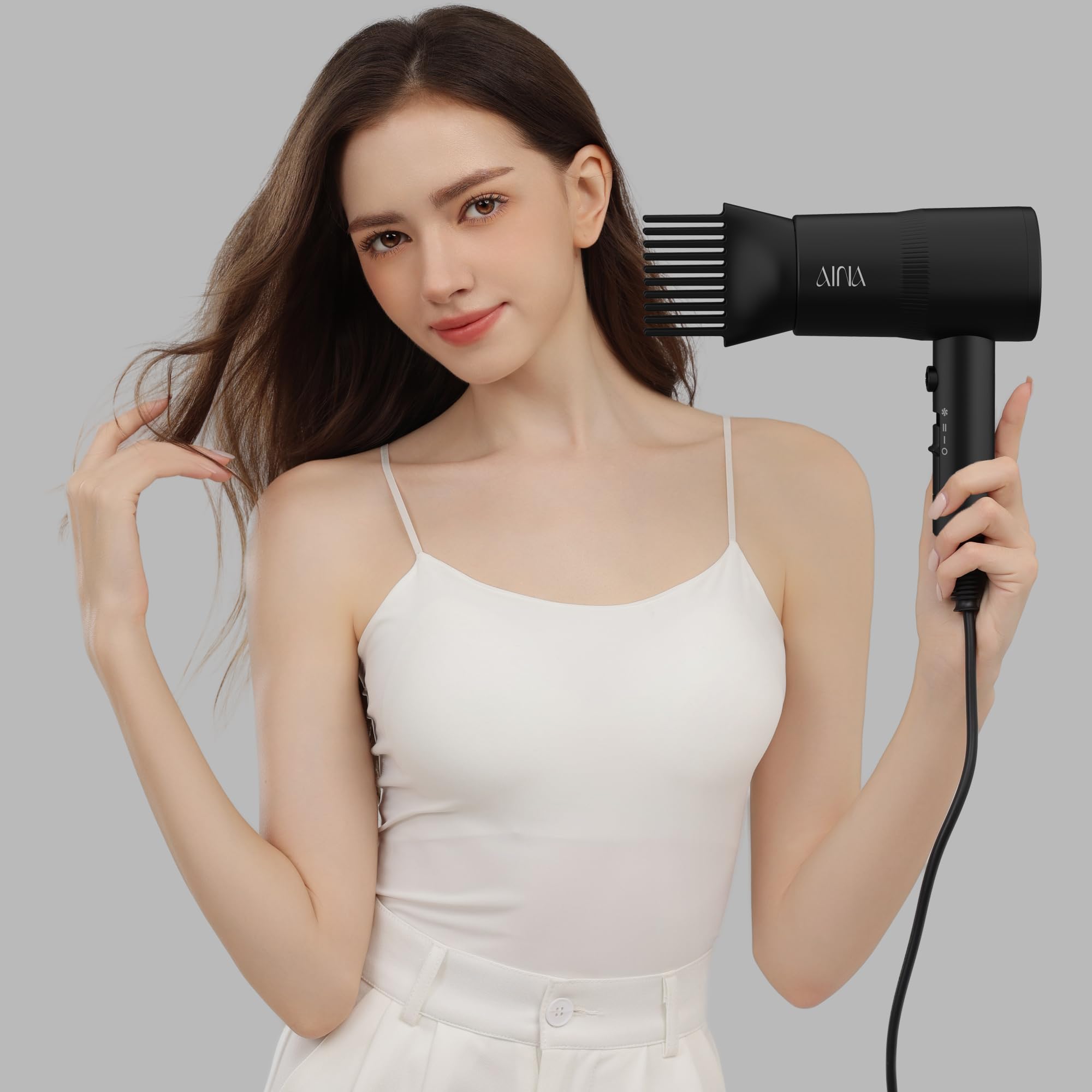 AINA hair dryer held in hand showing compact size for easy handling