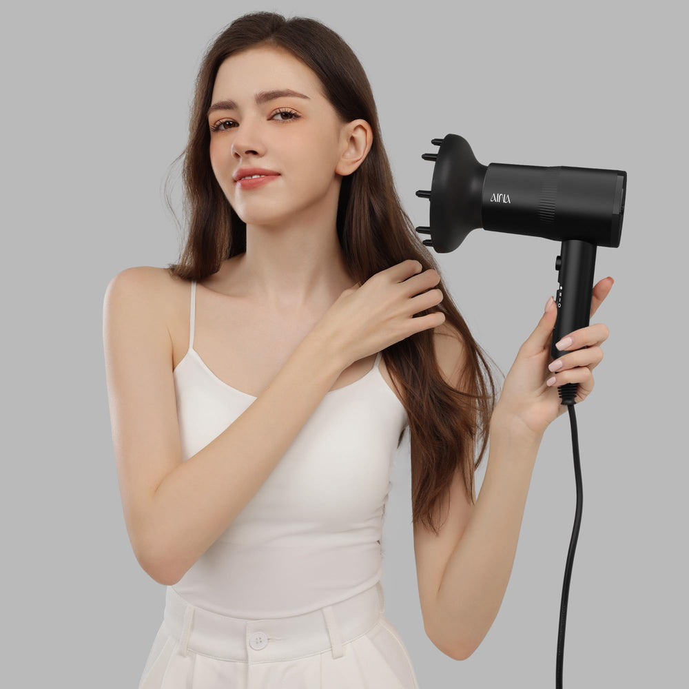 AINA next to a hand showing compact scale and travel-friendly convenience