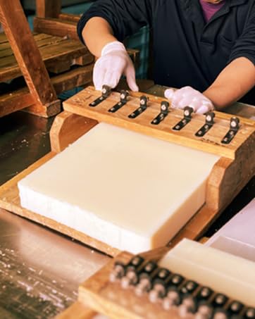 Asayu Japan soap next to coin showing scale and portability benefit