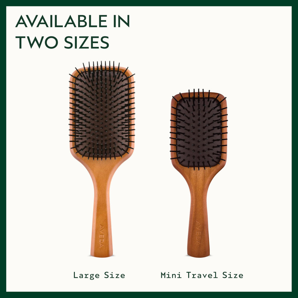 Lifestyle shot of Aveda brush beside styling products to show versatile routine compatibility