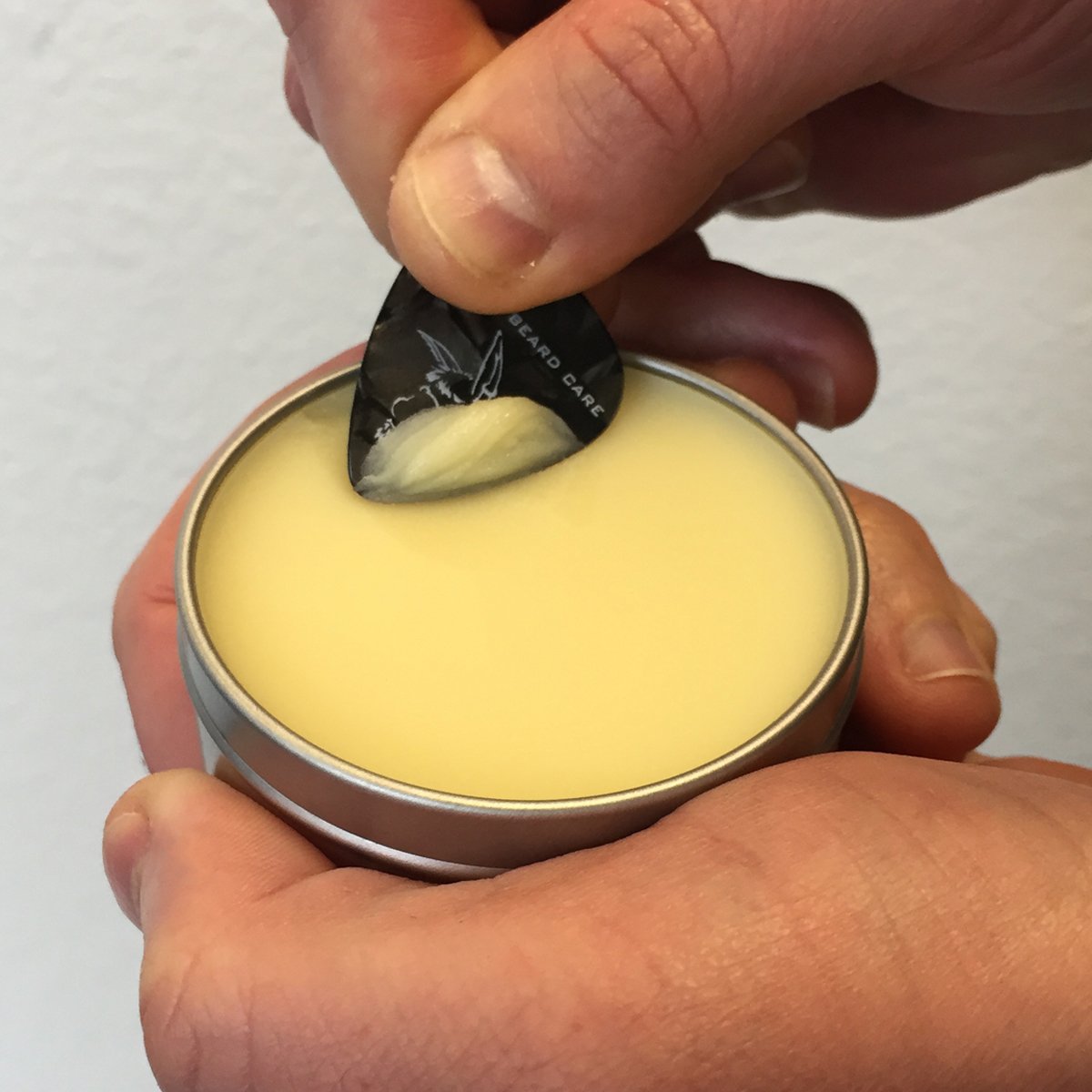 Badass Beard Care 2 oz tin next to coin for scale and portability benefit
