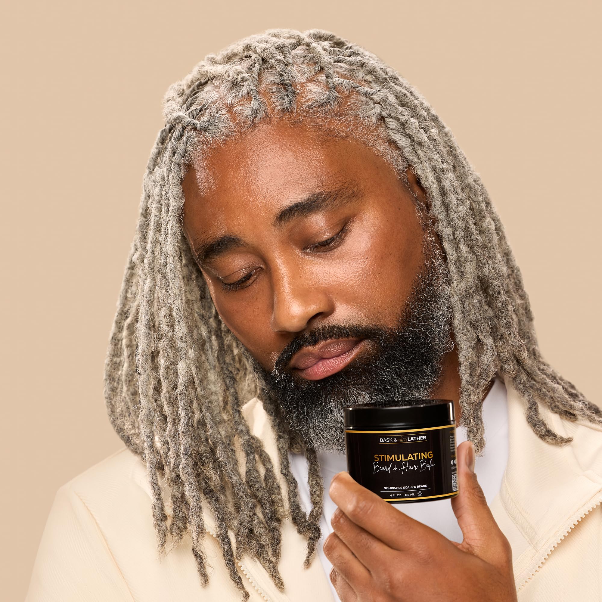 BASK & LATHER balm on fingers showing easy spreadability and precise application benefit