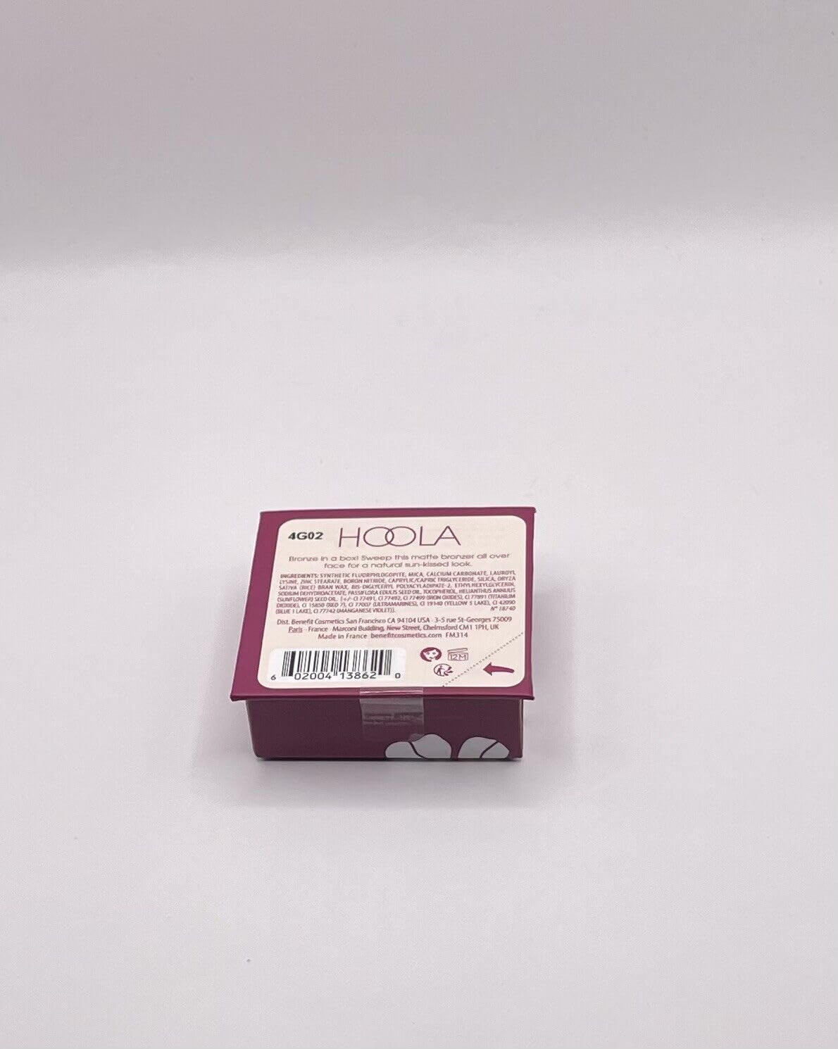 Benefit Hoola mini beside a coin for scale showing compact size benefit portable