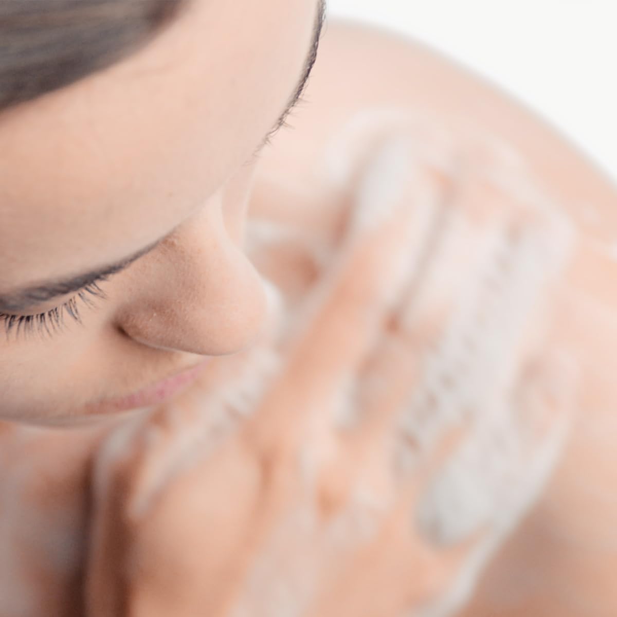 Person using Bioderma Atoderm on legs demonstrating body cleansing comfort