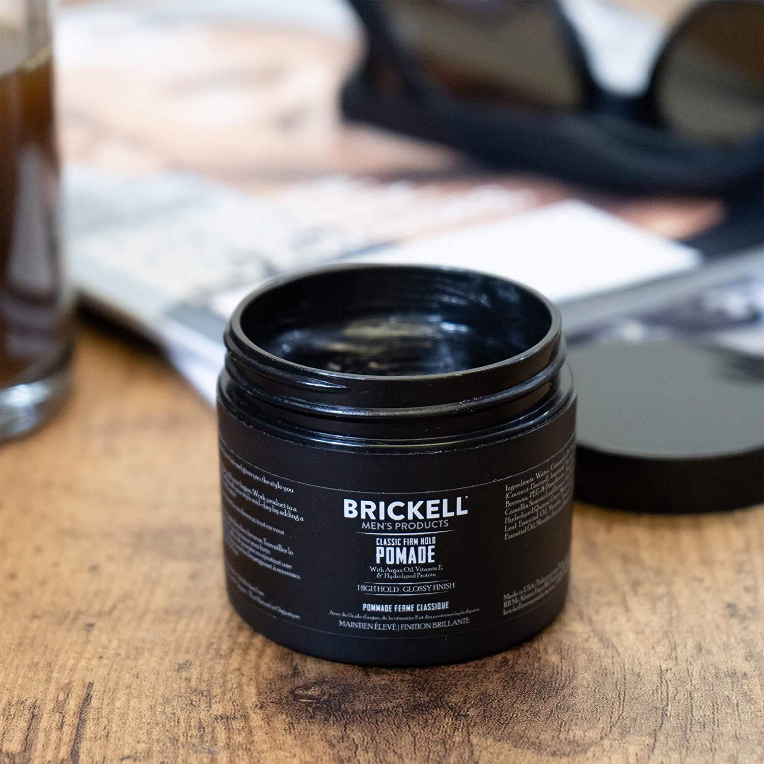 Applying Brickell pomade in hand demonstrating easy spread and control