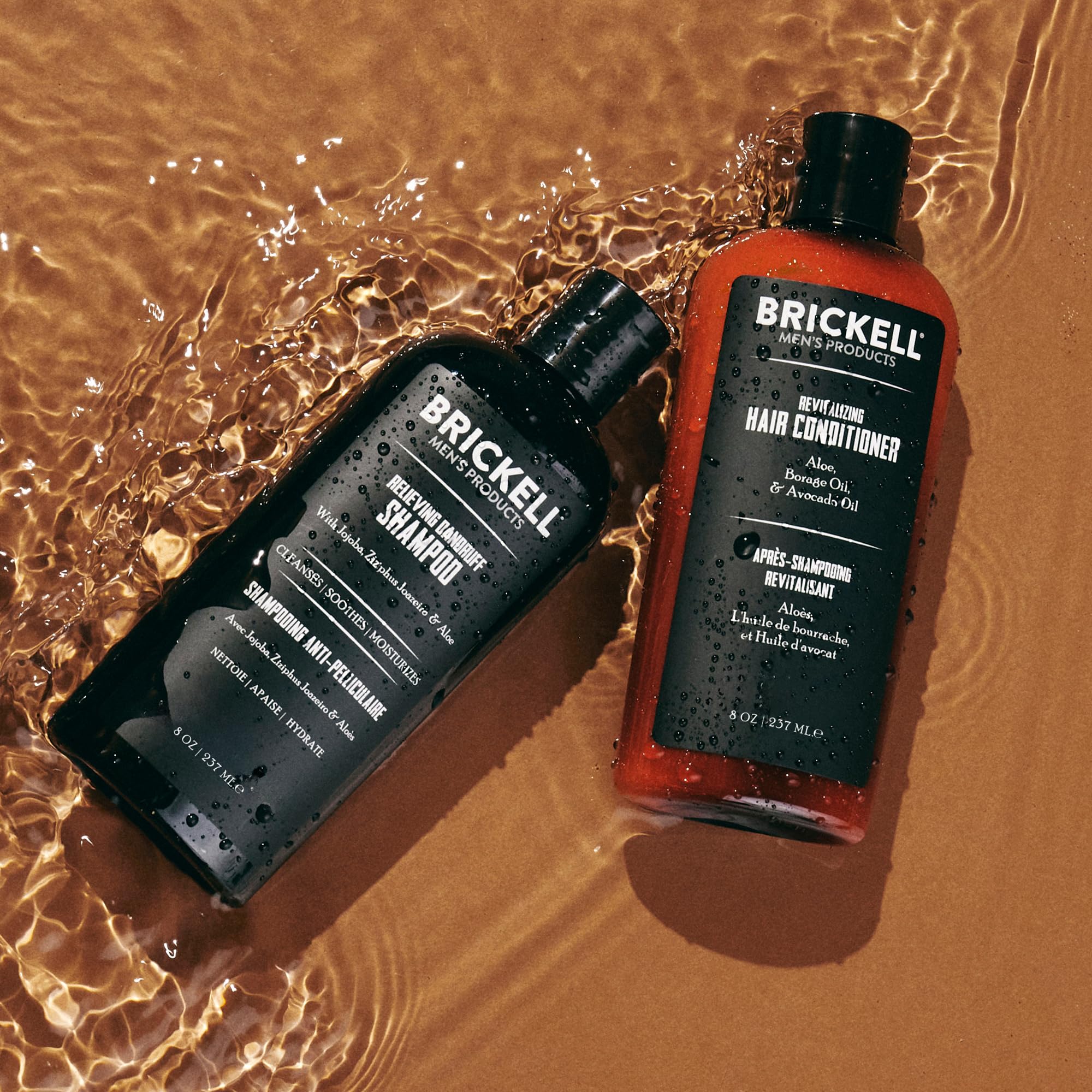 Brickell bottles next to a hand showing scale and travel-friendly size