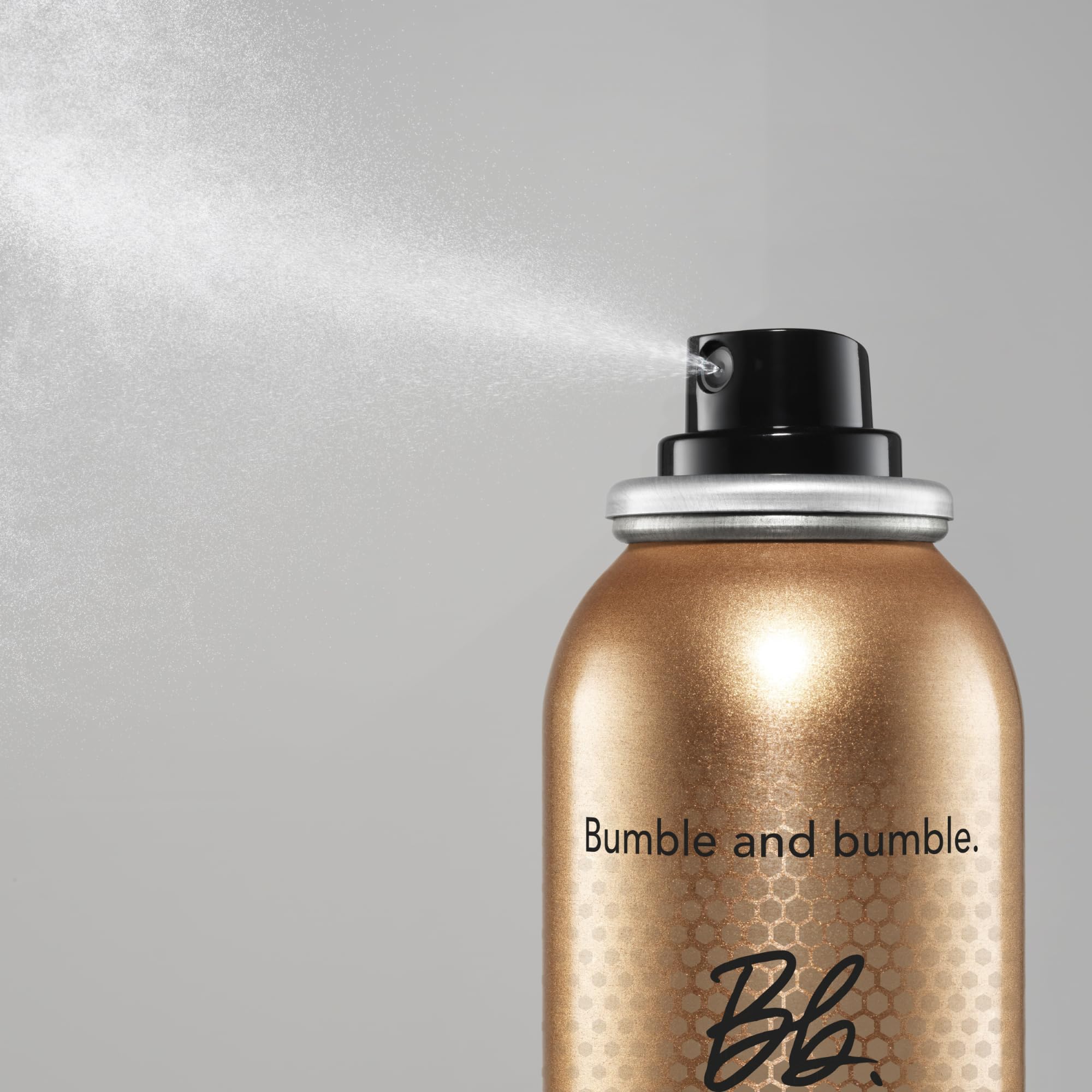 Model using Bumble and bumble Heat Shield while blow-drying hair, demonstrating faster styling benefit