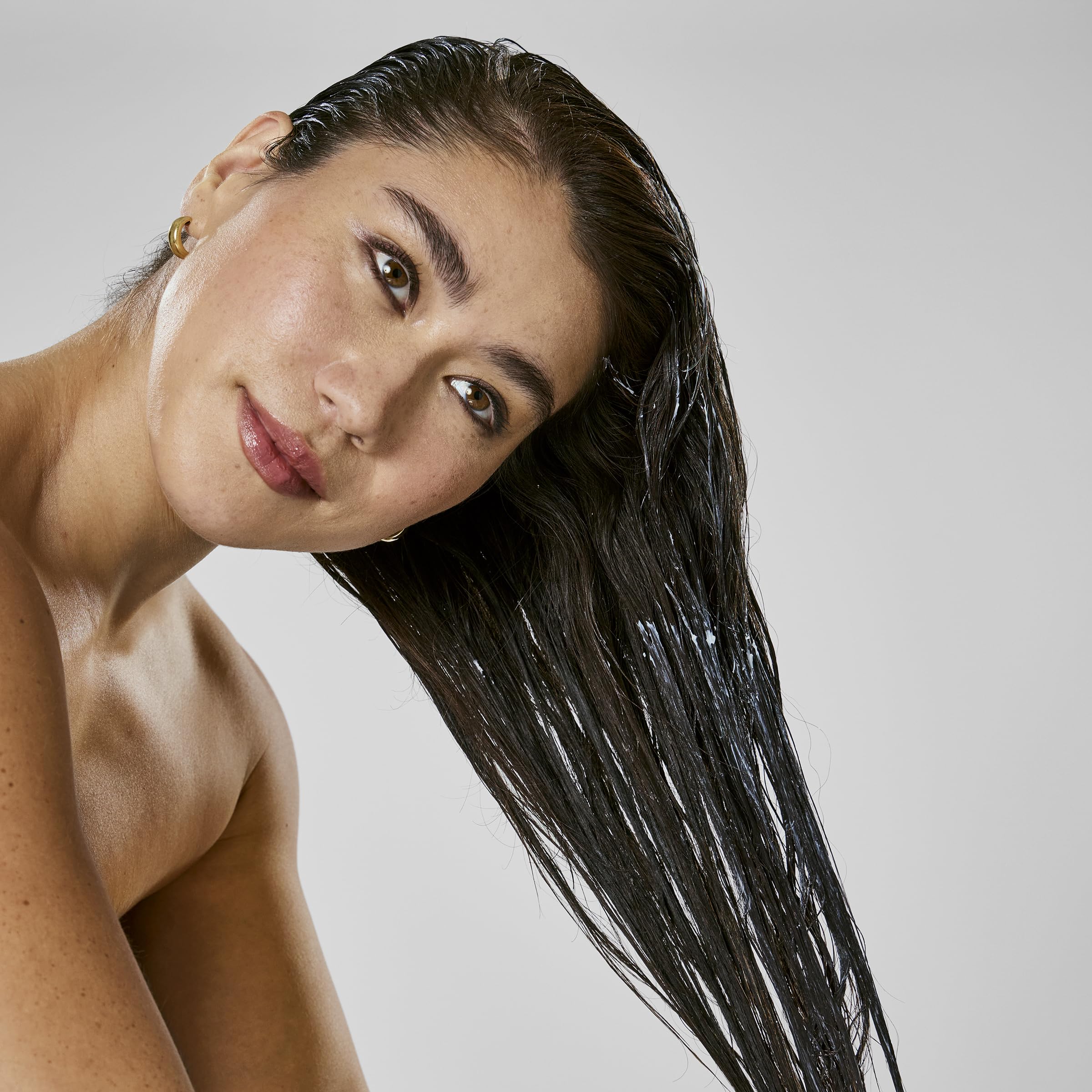 Bumble and bumble mask being applied to damp hair to demonstrate frizz control