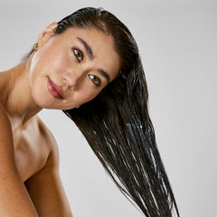 Bumble and bumble mask being applied to damp hair to demonstrate frizz control