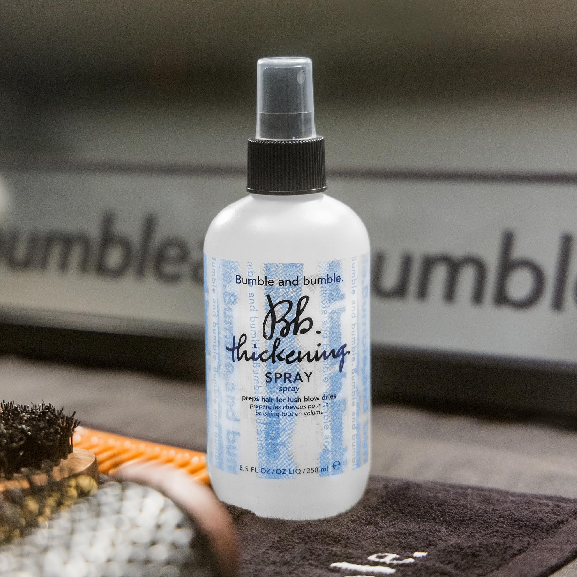 Bumble and bumble bottle held in hand illustrating mini size for portability benefit
