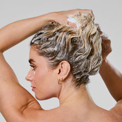 Bumble and bumble mini shampoo held in hand demonstrates travel size portability