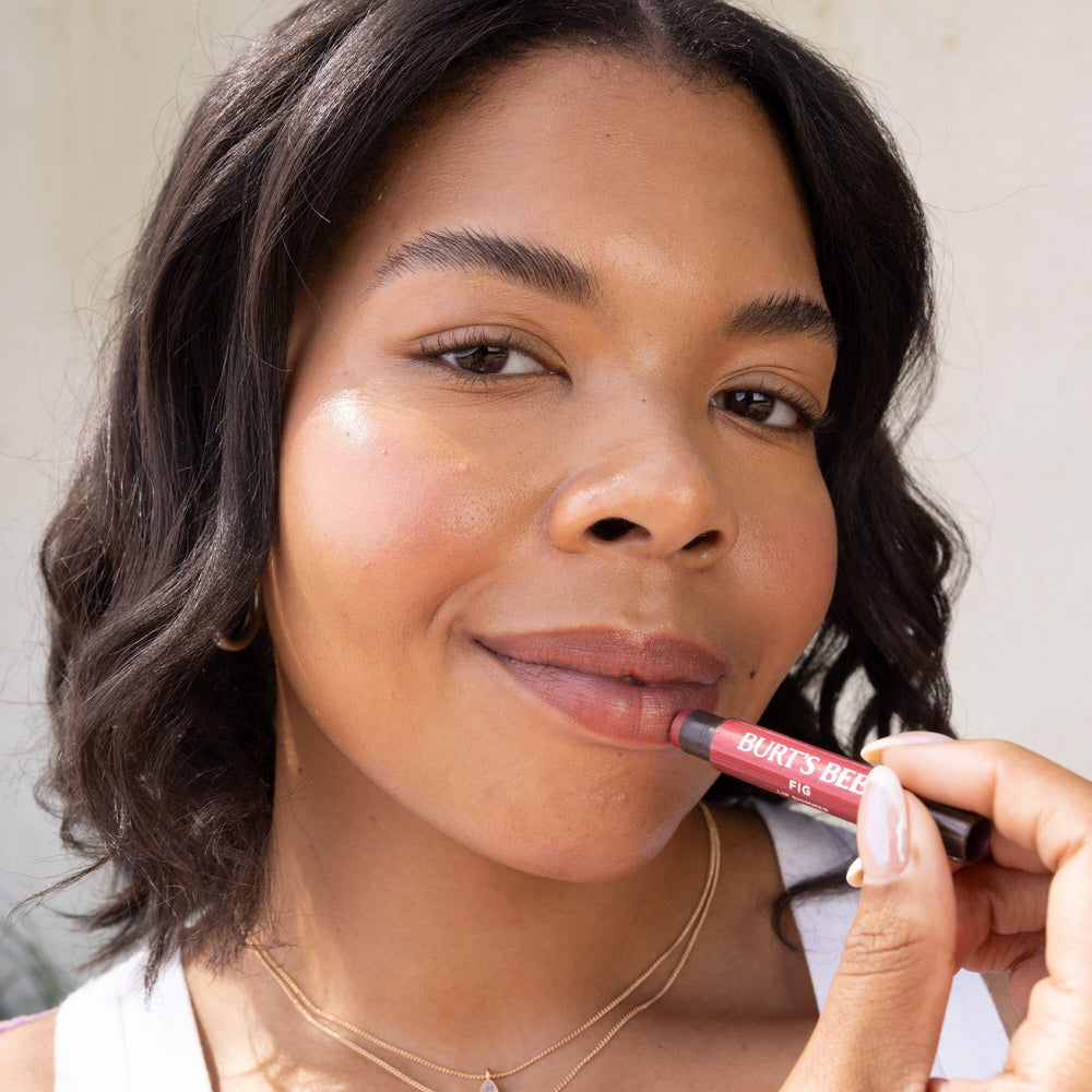 Burt's Bees applying tint to lips illustrating instant shimmer and hydration