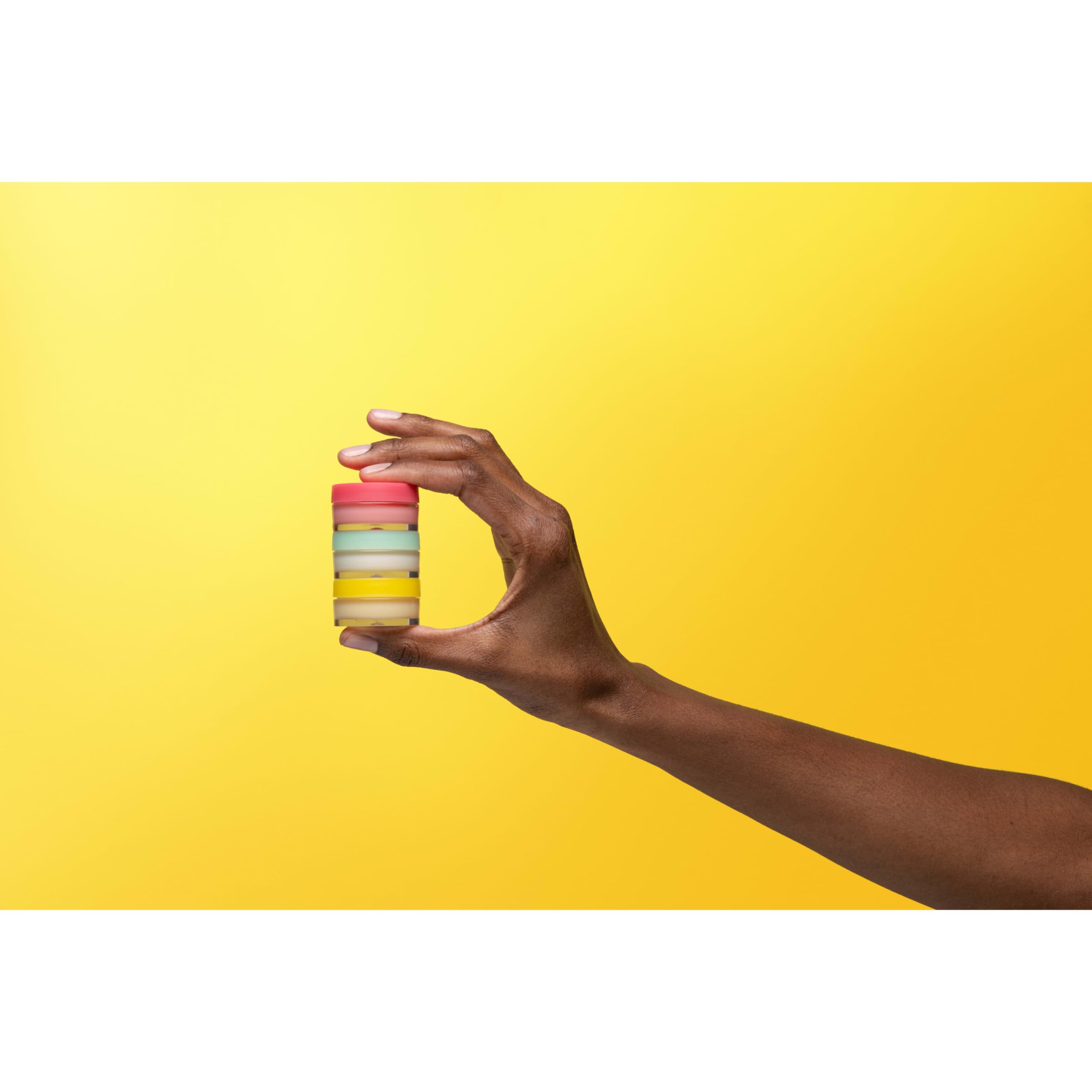 Burt's Bees jars next to fingers to show 0.25 oz size and portability benefit