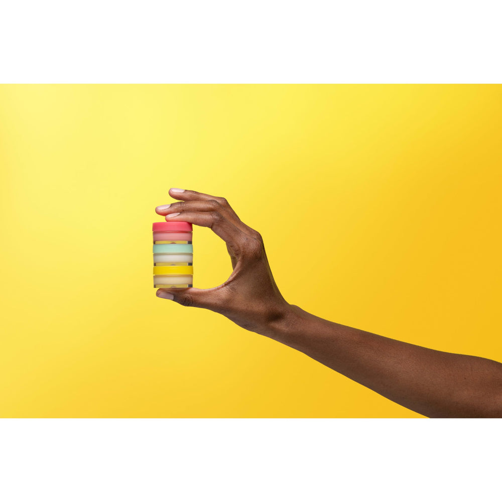 Burt's Bees jars next to fingers to show 0.25 oz size and portability benefit